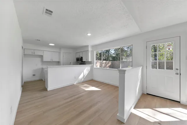 a view of a kitchen with wooden floor and windows