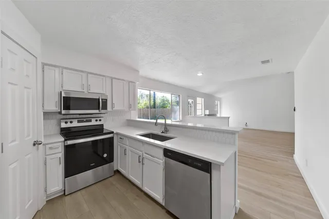 a kitchen with sink a microwave and cabinets