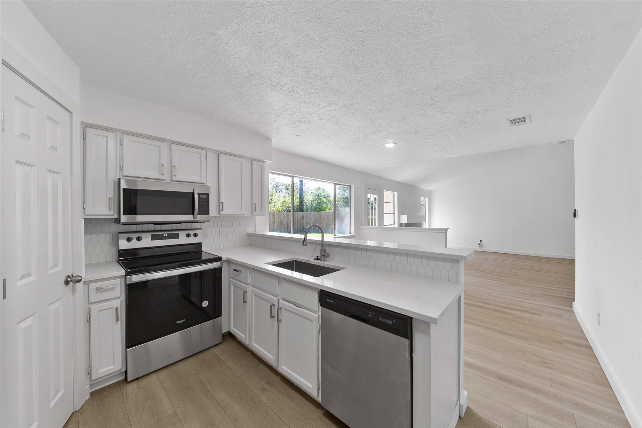 2042 Lexington Woods Drive Spring, TX 77373 - Photo 17 of 32 a kitchen with sink a microwave and cabinets
