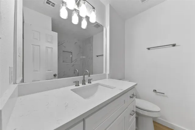 a bathroom with a sink a toilet and a mirror