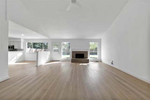 a view of a livingroom with wooden floor and a fireplace