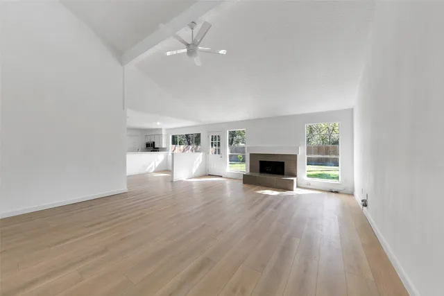 a view of empty room with wooden floor and fireplace