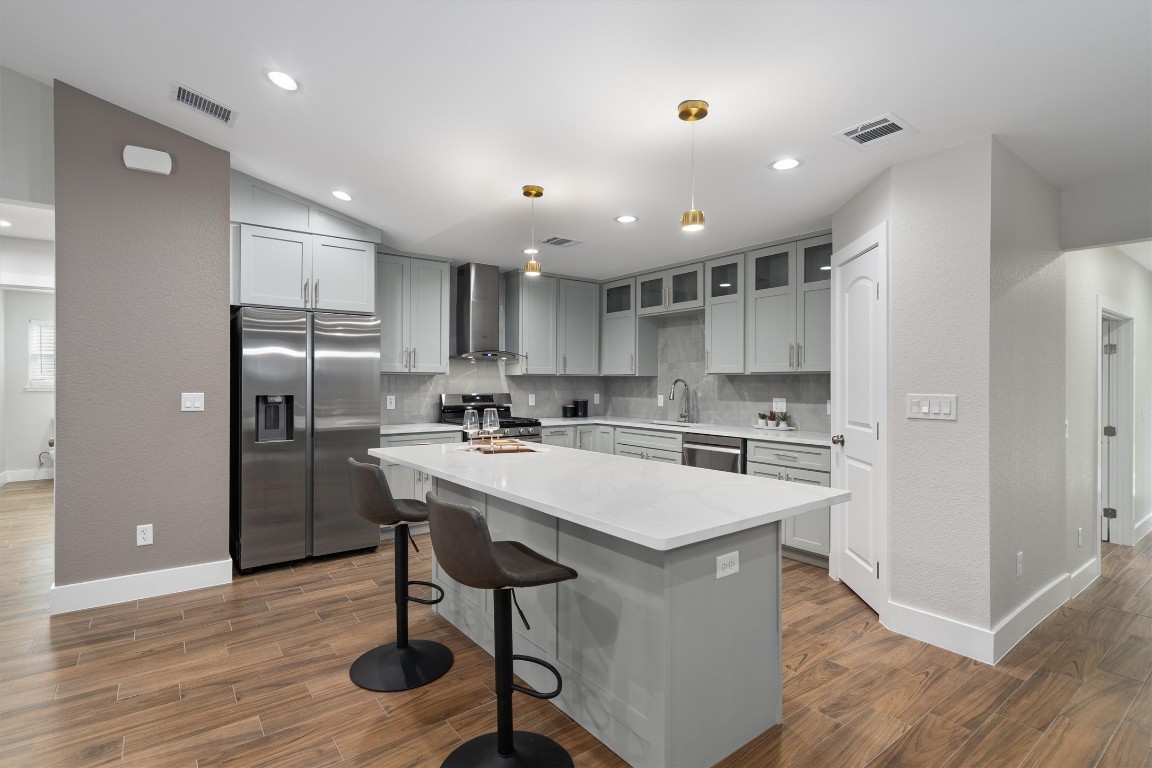 803 Glen Road Austin, TX 78753 - Photo 2 of 35 a kitchen with stainless steel appliances a refrigerator a stove a sink dishwasher and a refrigerator with wooden floor