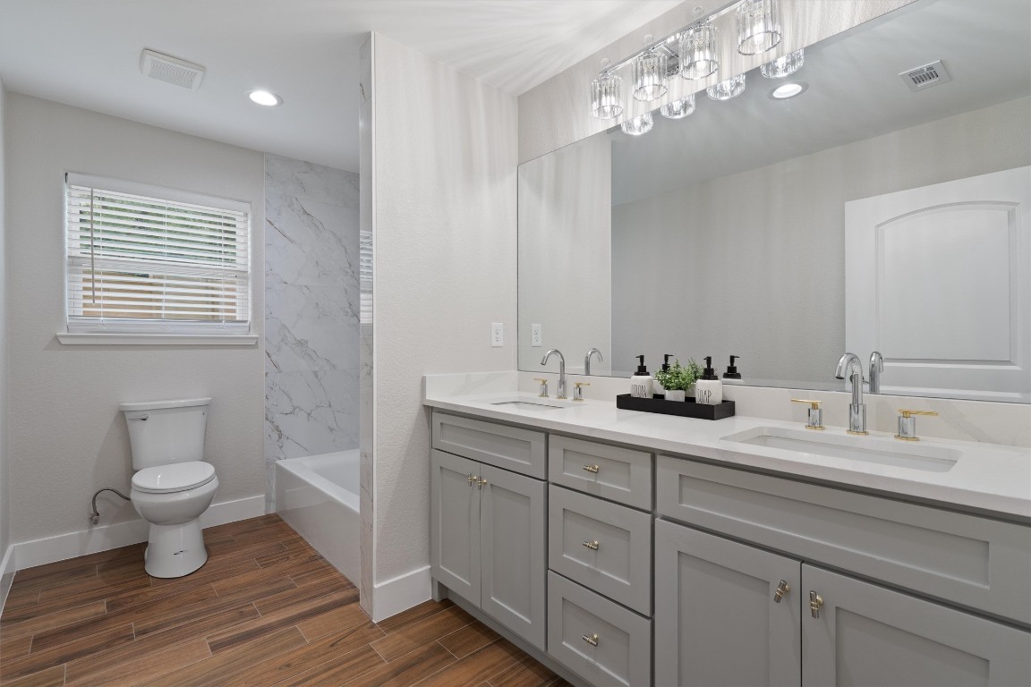 803 Glen Road Austin, TX 78753 - Photo 26 of 35 a bathroom with a toilet a sink and mirror