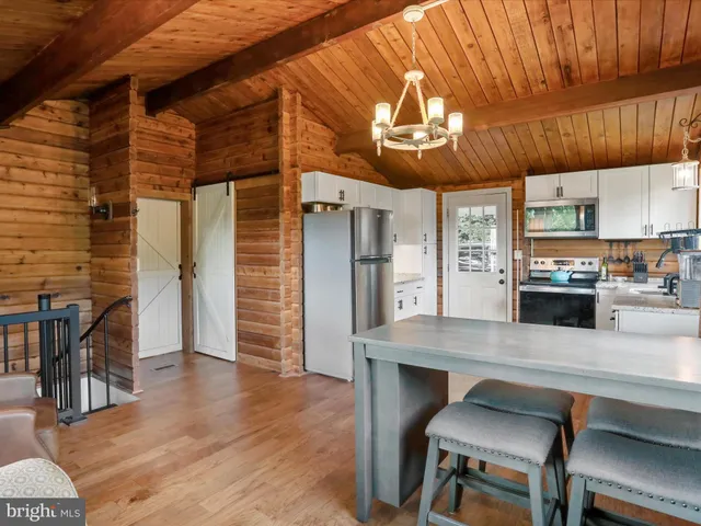 a kitchen with stainless steel appliances wooden floor table chairs and wooden floor