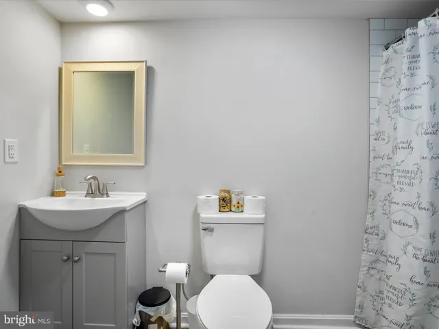 a bathroom with a toilet a sink and mirror