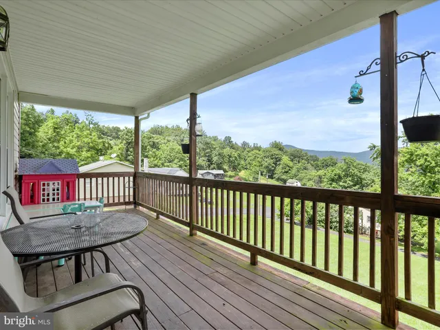 a balcony with wooden floor table and chairs