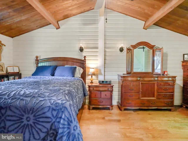 a bedroom with a bed and two mirrors