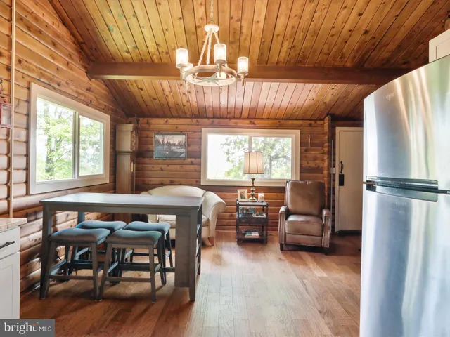 a dining room with furniture a chandelier and wooden floor
