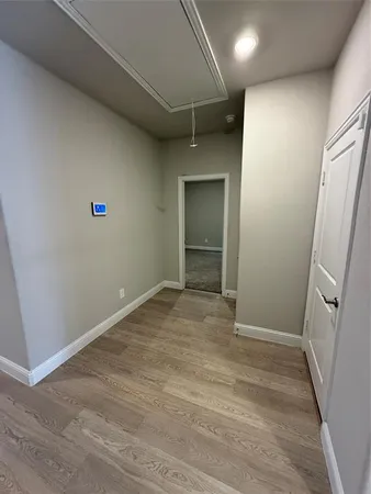 an empty room with wooden floor and entrance
