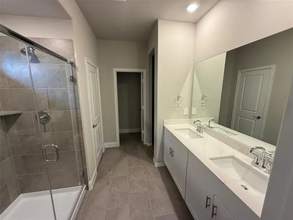 a bathroom with a double vanity sink mirror and shower