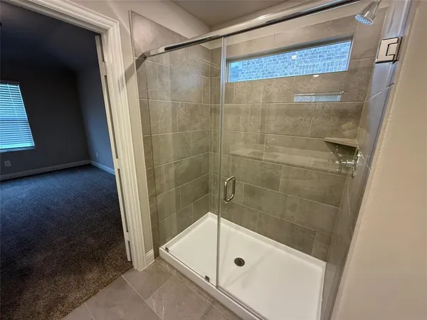 a bathroom with a glass door shower and a sink