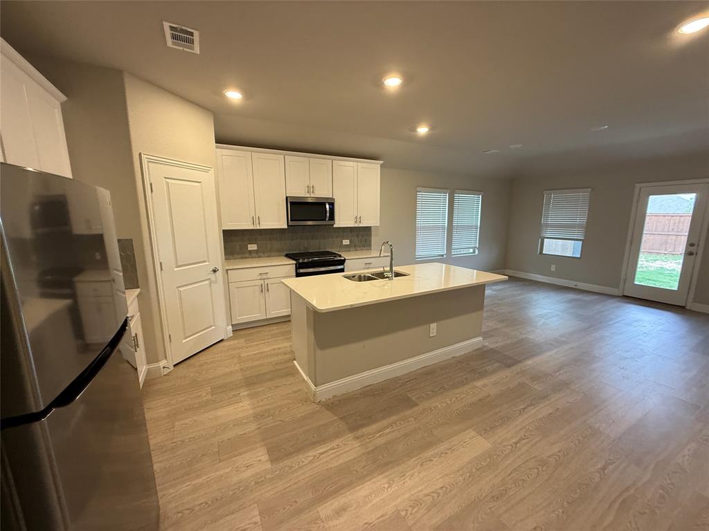 702 Williams Way Lowry Crossing, TX 75069 - Photo 3 of 22 a kitchen with stainless steel appliances a refrigerator sink and microwave
