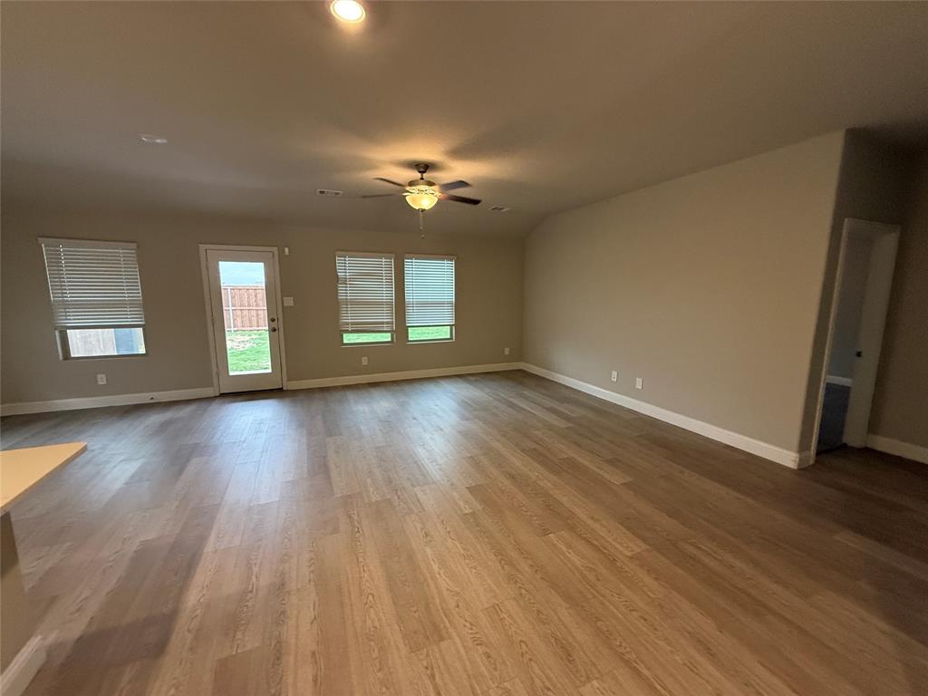 702 Williams Way Lowry Crossing, TX 75069 - Photo 4 of 22 a view of an empty room with wooden floor and a window