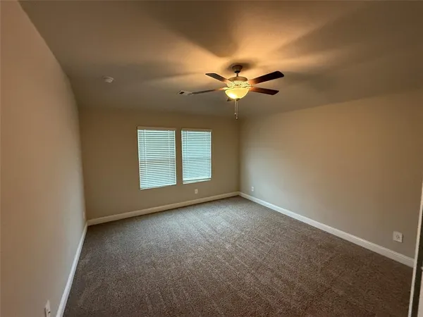 an empty room with a ceiling fan and a window