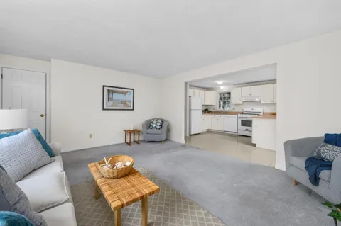 a kitchen with stainless steel appliances granite countertop a refrigerator sink stove and white cabinets