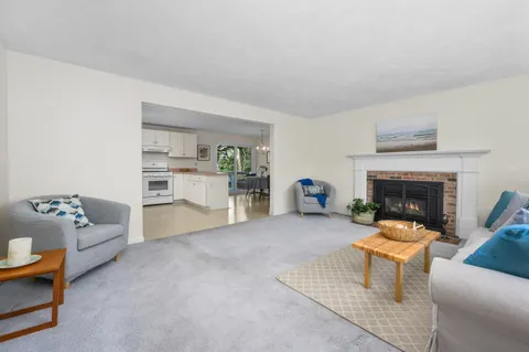 a kitchen with stainless steel appliances granite countertop a refrigerator a stove a sink and white cabinets with wooden floor