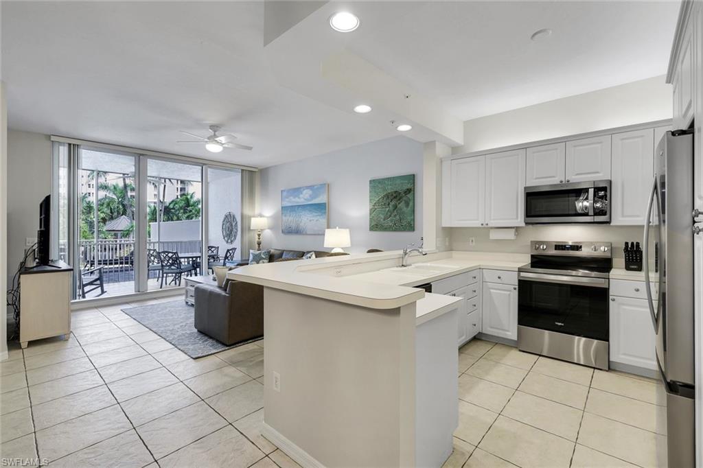 460 Launch Circle, Unit 202 Naples, FL 34108 - Photo 8 of 34 a kitchen with stainless steel appliances granite countertop a sink dishwasher stove top oven and cabinets