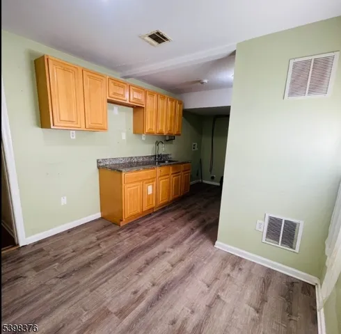 a kitchen with granite countertop wooden floors and wide window
