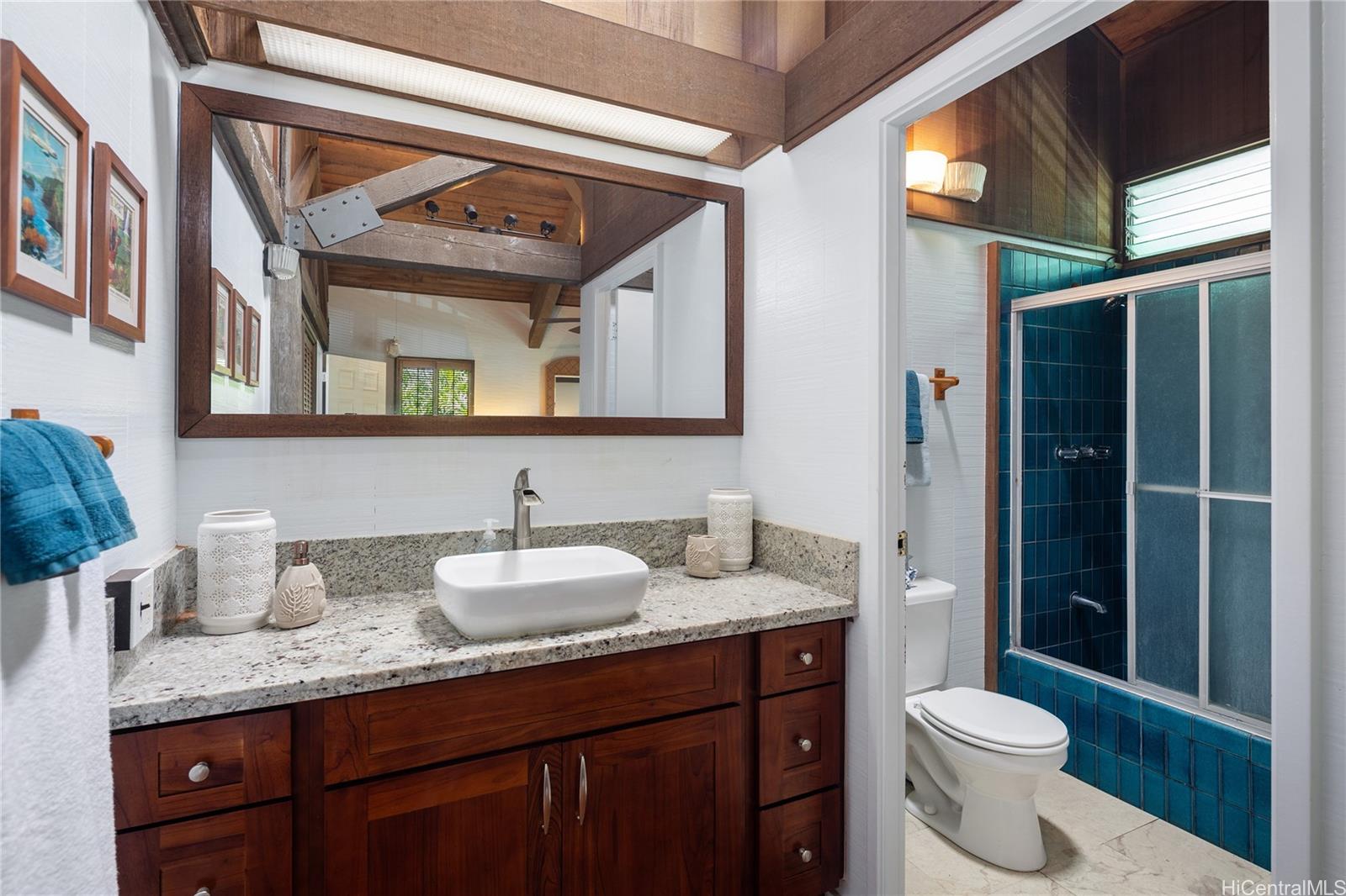 67-421 Waialua Beach Road Waialua, HI 96791 - Photo 20 of 25 a bathroom with a granite countertop sink and a toilet