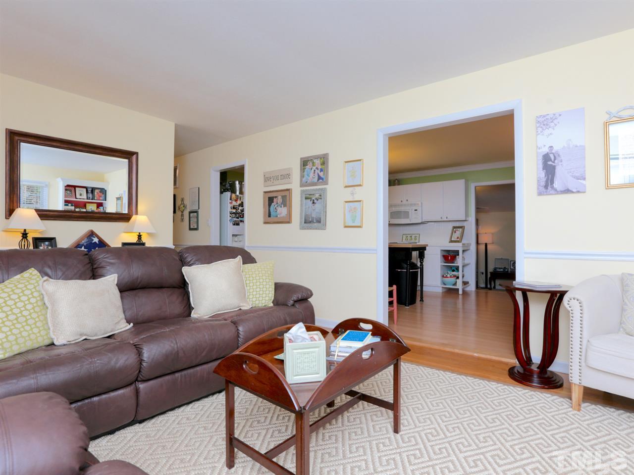 403 Kevin Circle Raleigh, NC 27609 - Photo 6 of 25 a living room with furniture a flat screen tv and a wall paintings