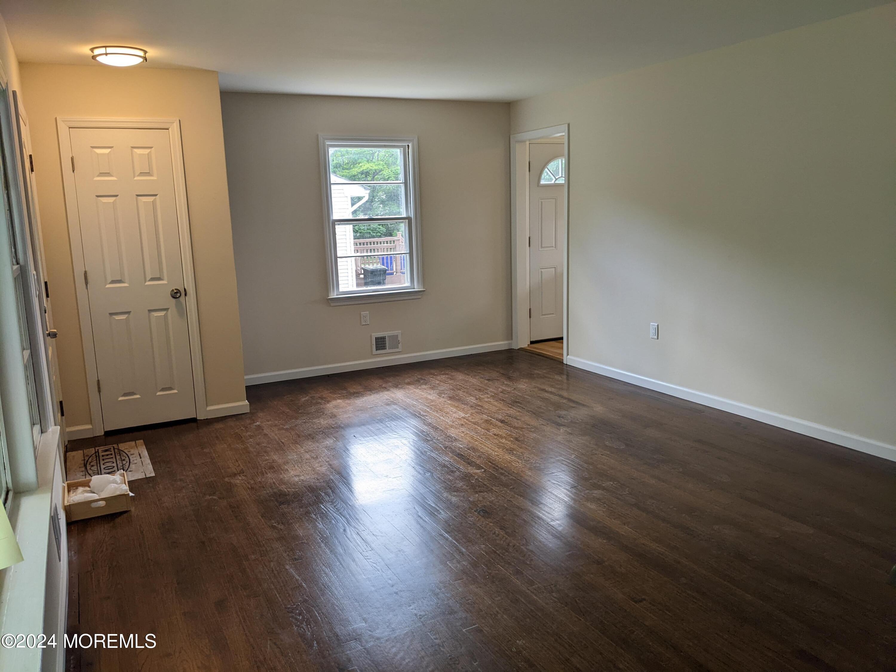 509 Stone Road Union Beach, NJ 07735 - Photo 7 of 16 an empty room with wooden floor and a window