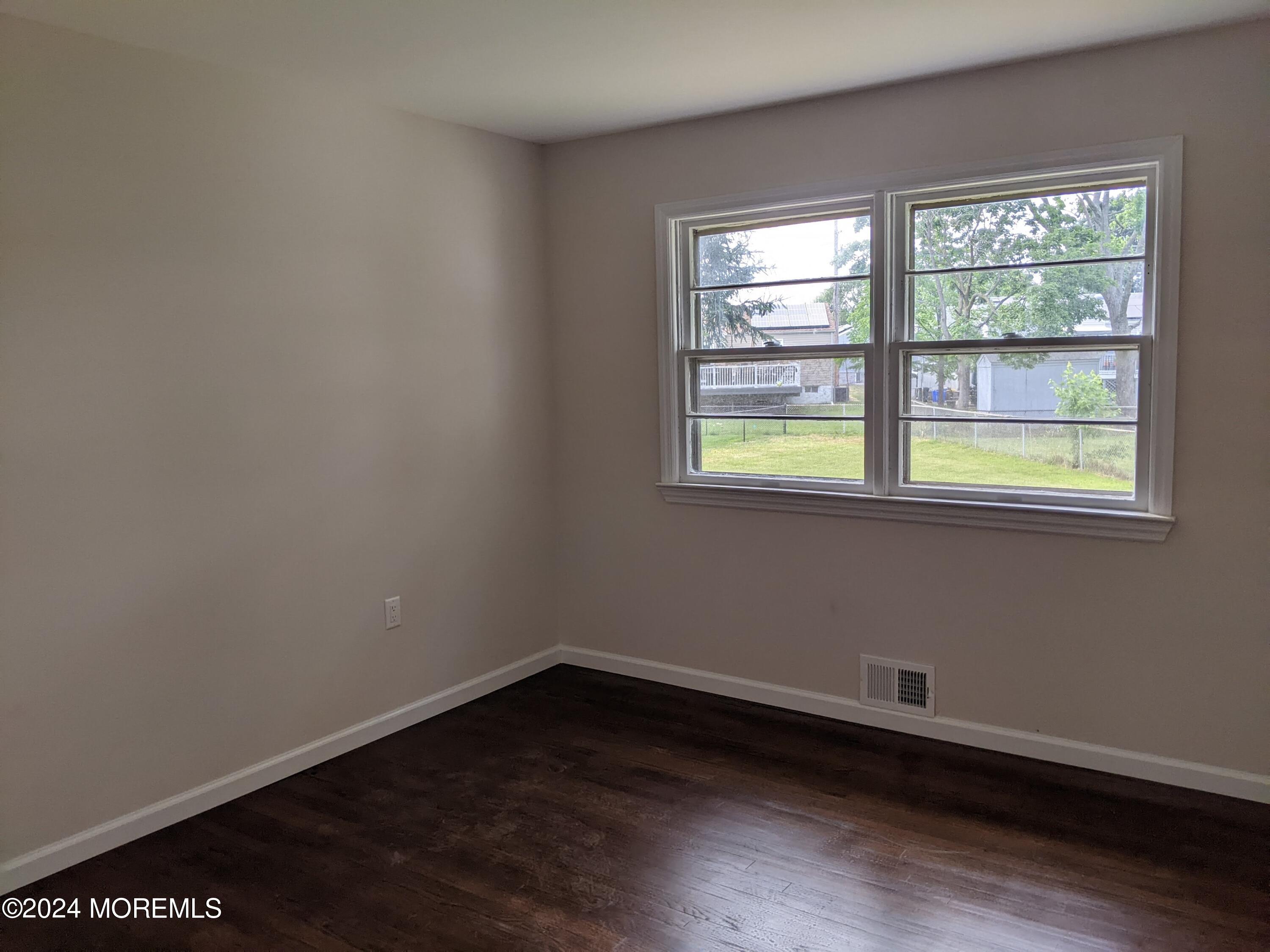 509 Stone Road Union Beach, NJ 07735 - Photo 8 of 16 a view of an empty room with wooden floor and a window