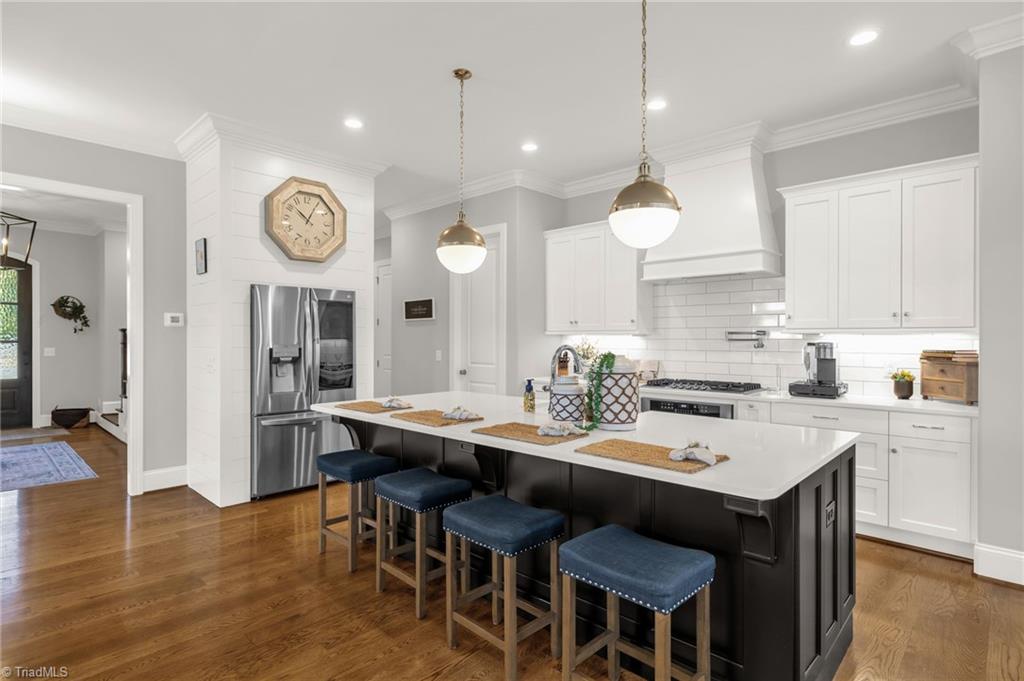 4262 Bridgehead Road Kernersville, NC 27284 - Photo 13 of 50 Kitchen Angle 2 – Stainless-steel appliances, designer hardware, and custom vent hood enhance the timeless, high-end aesthetic.
