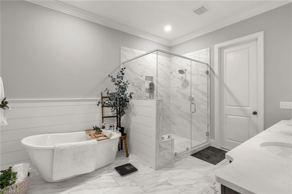 4262 Bridgehead Road Kernersville, NC 27284 - Photo 19 of 50 Primary Bath – Spa-inspired bath with marble-look tile, freestanding soaking tub, frameless glass shower, and dual vanities in a soft gray finish.