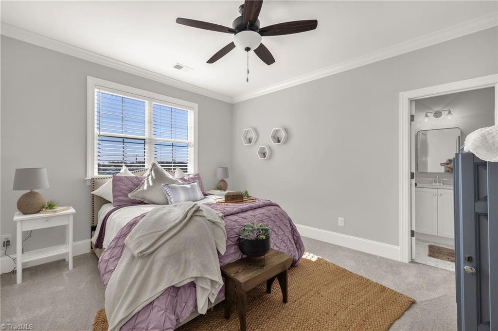 4262 Bridgehead Road Kernersville, NC 27284 - Photo 25 of 50 Upstairs Bedroom – Bright and airy secondary bedroom featuring neutral tones, crown molding, and a ceiling fan for year-round comfort.