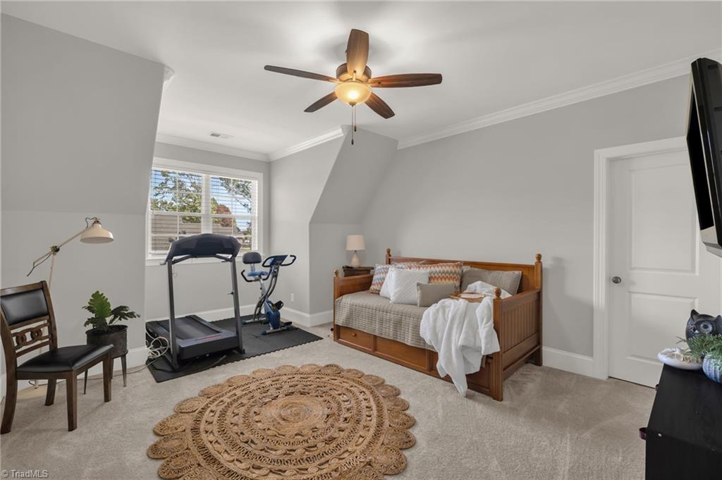4262 Bridgehead Road Kernersville, NC 27284 - Photo 30 of 50 Upstairs Bedroom – Comfortable secondary bedroom with soft neutral tones, ceiling fan, and large window for abundant natural light.