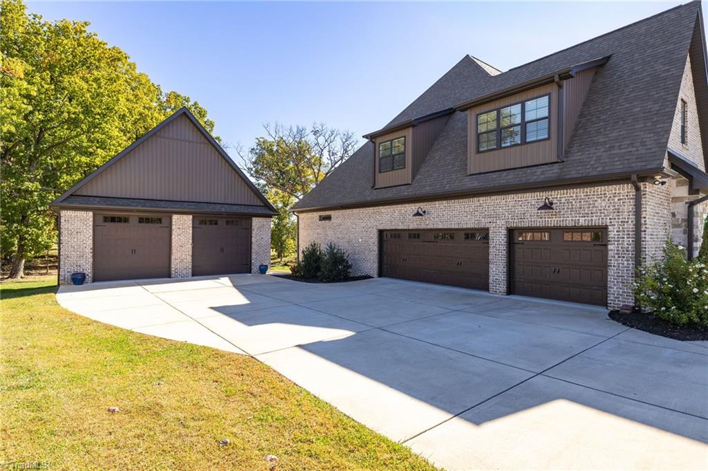4262 Bridgehead Road Kernersville, NC 27284 - Photo 3 of 50 Garages – Expansive parking with a three-car attached garage plus a two-car detached garage/shop, offering flexibility for storage or hobbies.