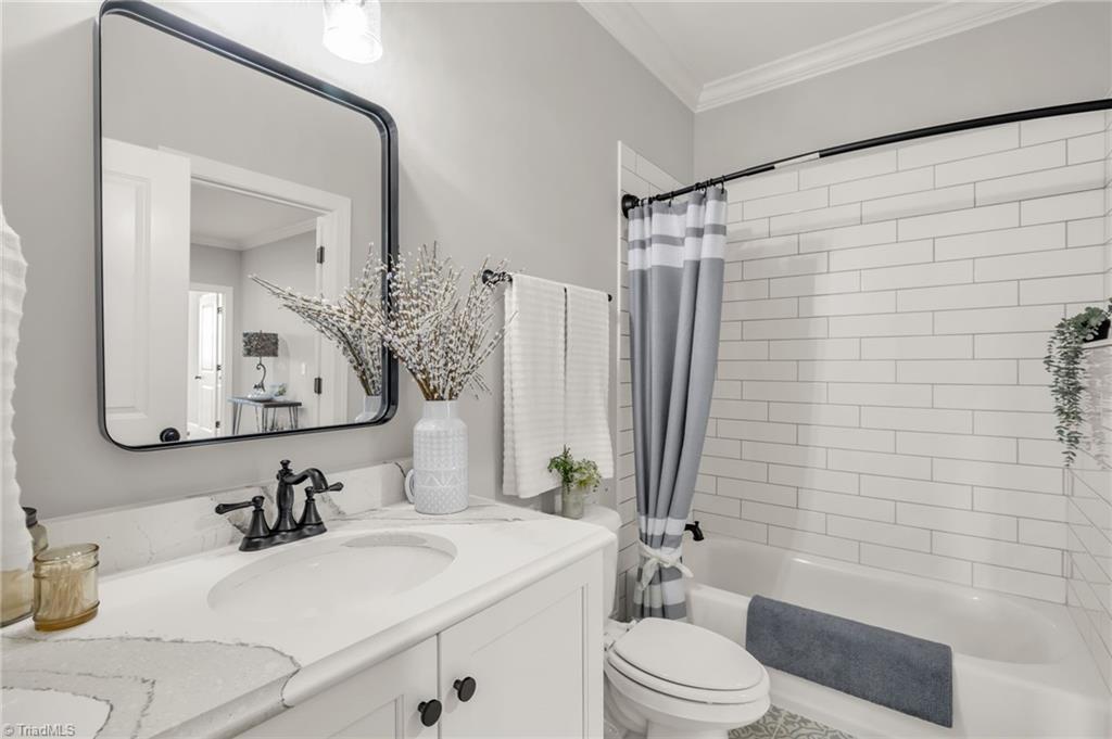 4262 Bridgehead Road Kernersville, NC 27284 - Photo 31 of 50 Upstairs Bathroom – Stylish full bath featuring subway-tile tub surround, marble countertop vanity, and polished chrome fixtures with bright natural light.