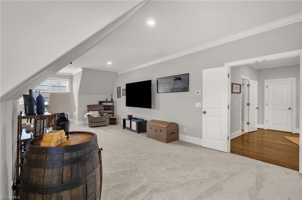 4262 Bridgehead Road Kernersville, NC 27284 - Photo 33 of 50 Bonus room media area with large wall-mounted TV, built-in wiring access, and plenty of room for cozy seating or movie-night gatherings.