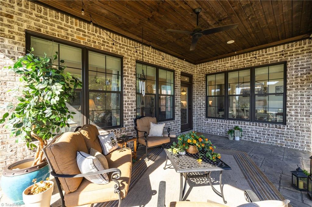4262 Bridgehead Road Kernersville, NC 27284 - Photo 38 of 50 Screened Porch Alternate – Brick detailing and warm tones create a cozy outdoor living area perfect for morning coffee or evening gatherings.
