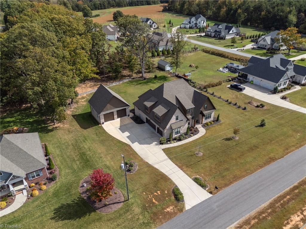 4262 Bridgehead Road Kernersville, NC 27284 - Photo 50 of 50 Aerial Side Angle – Captures the home’s architectural presence, detached garage, and manicured landscaping from an elevated viewpoint.