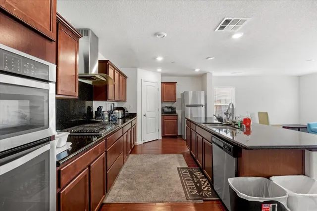a kitchen with stainless steel appliances granite countertop a sink stove and refrigerator