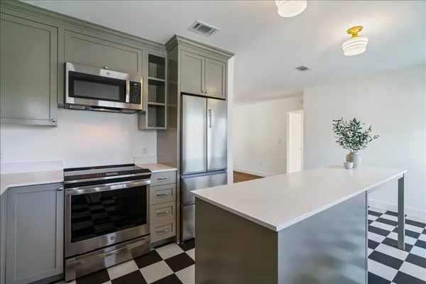 a kitchen with stainless steel appliances a stove a sink and a refrigerator