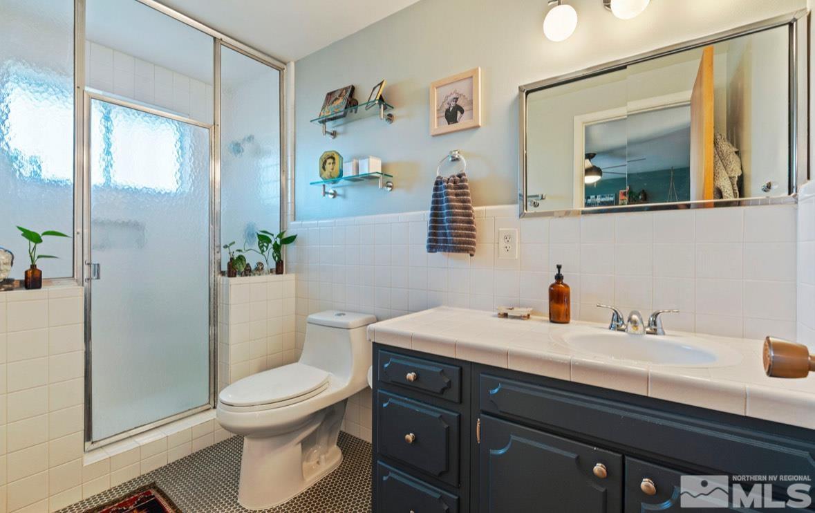 1775 Carlin Street Reno, NV 89503 - Photo 13 of 20 a bathroom with a toilet a sink and mirror