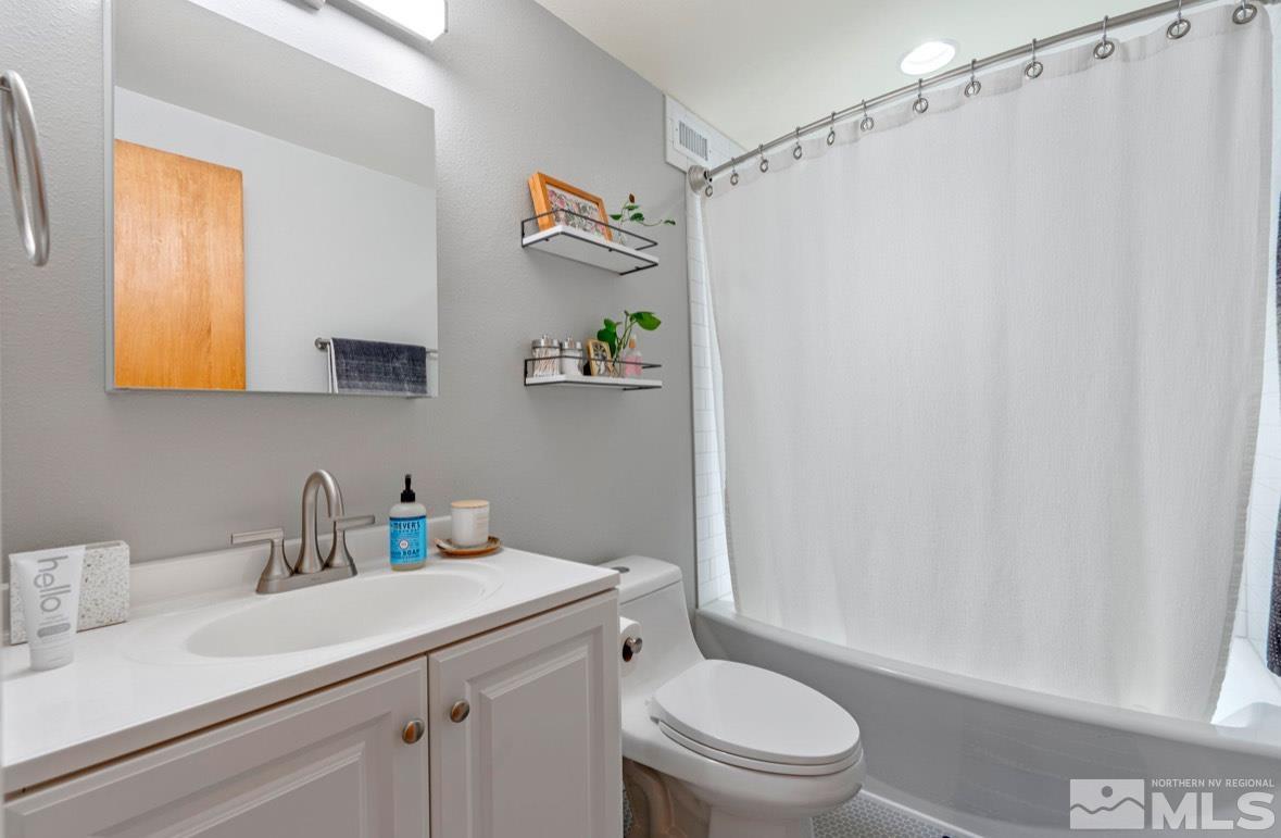 1775 Carlin Street Reno, NV 89503 - Photo 17 of 20 a bathroom with a sink a toilet and shower curtain