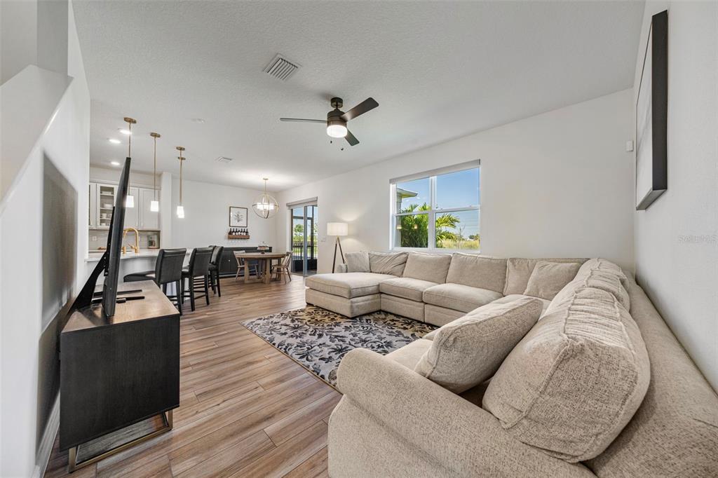 11430 Gallatin Trail Parrish, FL 34219 - Photo 21 of 79 a living room with furniture kitchen view and a chandelier