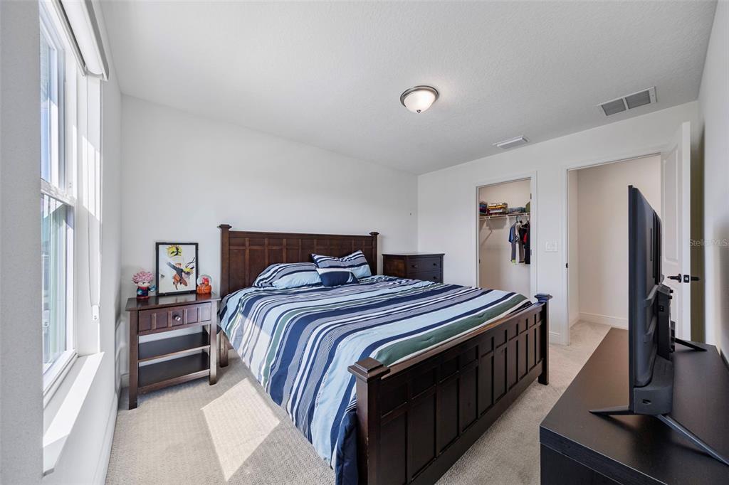 11430 Gallatin Trail Parrish, FL 34219 - Photo 43 of 79 a bedroom with a bed and a flat tv screen on a dresser