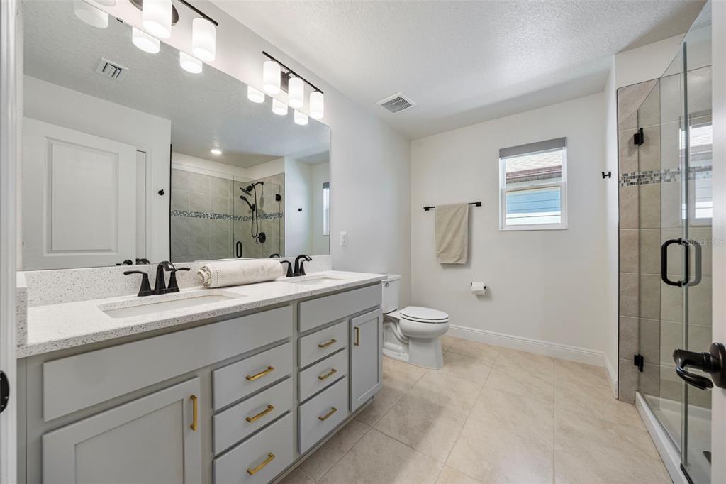 11430 Gallatin Trail Parrish, FL 34219 - Photo 7 of 79 a spacious bathroom with a double vanity sink toilet mirror and shower