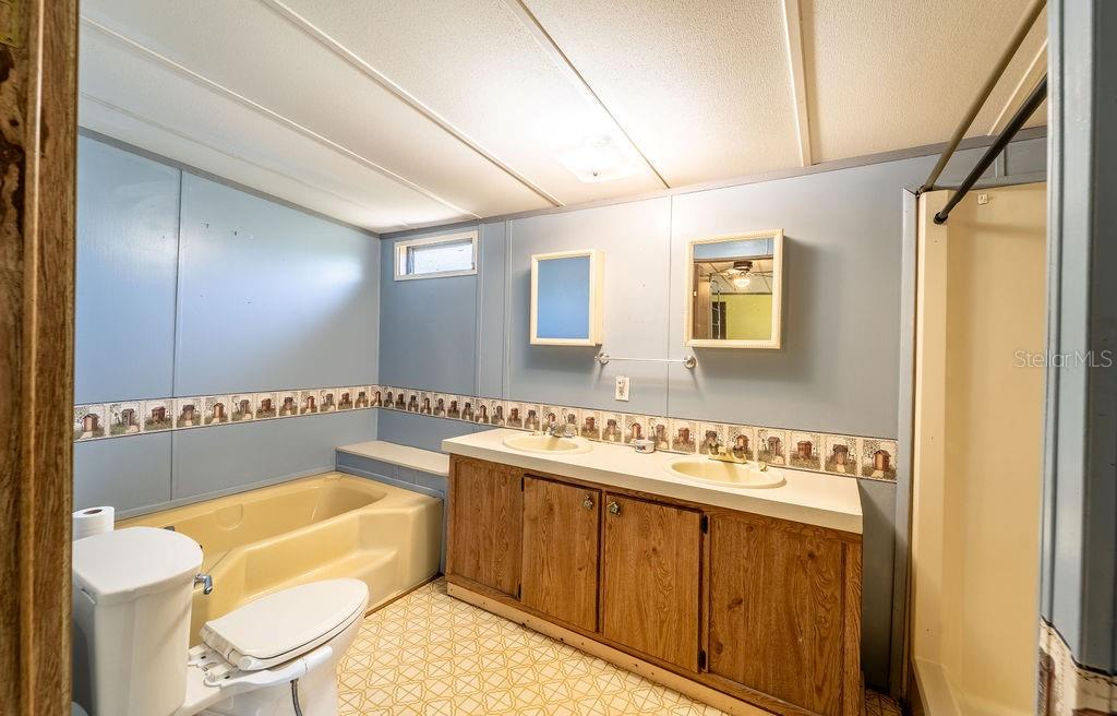 24031 Armadillo Road Astor, FL 32102 - Photo 22 of 43 a bathroom with a tub sink mirror and toilet