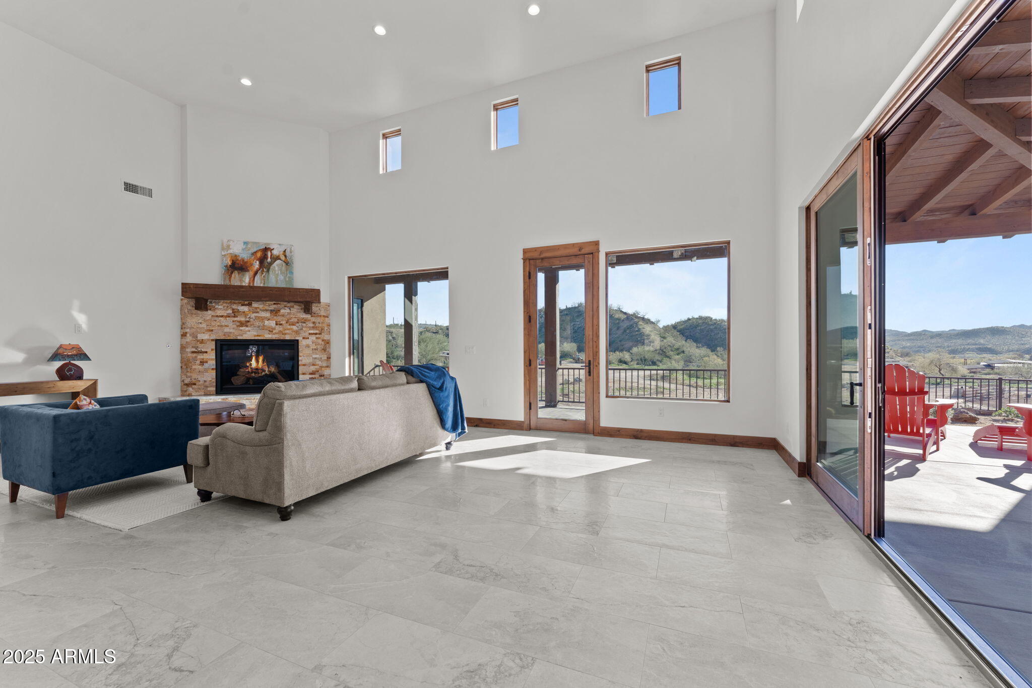 30100 Walter Road Wickenburg, AZ 85390 - Photo 27 of 66 a living room with furniture a fireplace and a floor to ceiling window