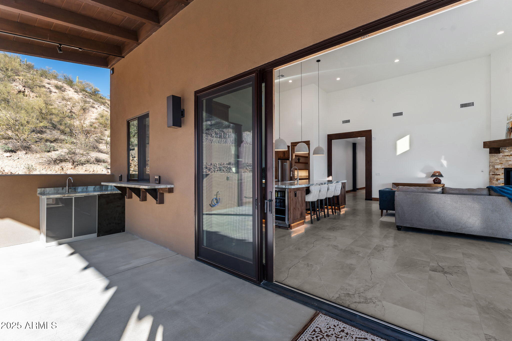 30100 Walter Road Wickenburg, AZ 85390 - Photo 29 of 66 a living room with couches a flat tv screen and a dining table with garden view