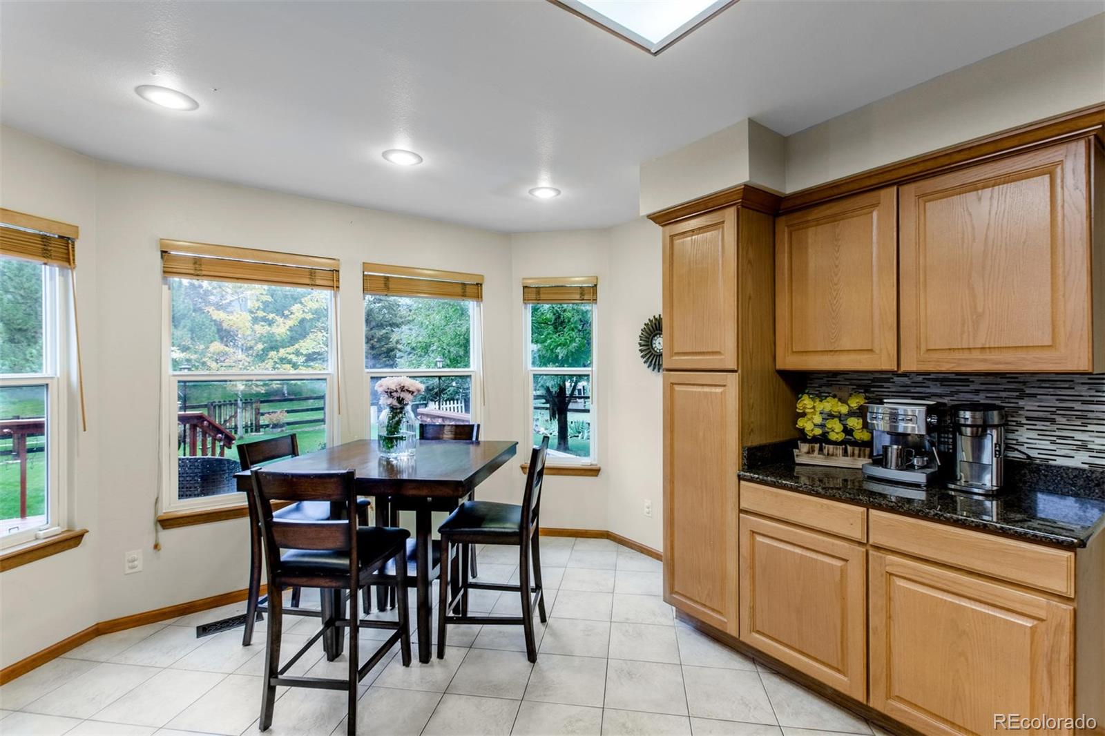 10037 Hooker Street Westminster, CO 80031 - Photo 12 of 40 a kitchen with stainless steel appliances granite countertop sink refrigerator dining table and chairs