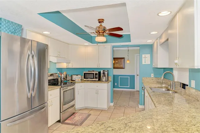 a kitchen with stainless steel appliances granite countertop a dining table and chairs