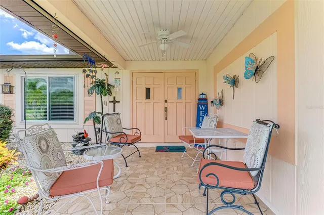 a living room with patio furniture and a chandelier