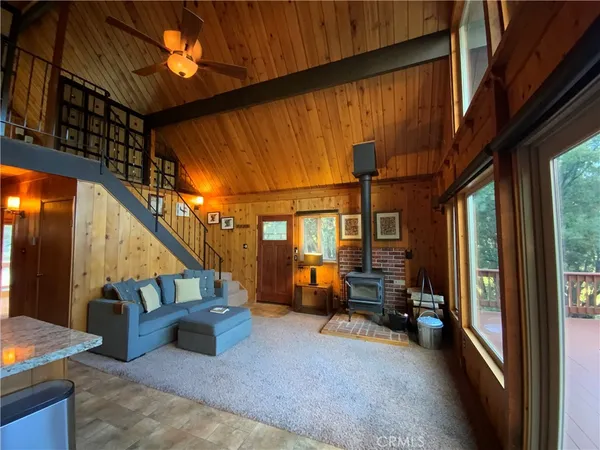a living room with furniture a flat screen tv and a floor to ceiling window
